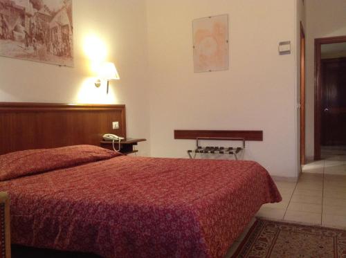 1 dormitorio con 1 cama con colcha roja en El Hana International en Túnez