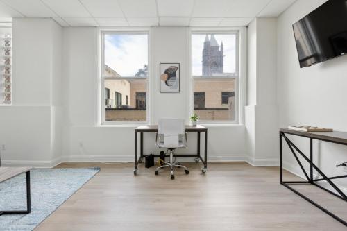 an office with a desk and two windows at East 225 I Modern Studio In Downtown Rochester in Rochester