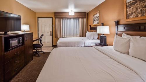 a hotel room with two beds and a flat screen tv at Best Western PLUS Ruby's Inn in Bryce Canyon