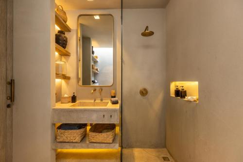 a bathroom with a sink and a mirror at The Konkret Lombok in Kuta Lombok