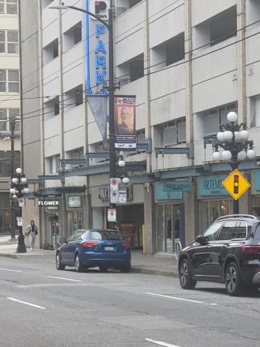 two cars parked on a street in front of a building at Downtown Center Silverstone Tower I and II Long-Term Booking Only Your second home in Vancouver in Vancouver