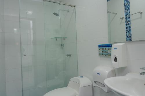 a bathroom with a shower and a toilet and a sink at Hotel Aguamarina in Santa Marta