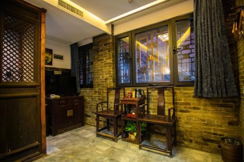 a living room with a brick wall and a window at Pingyao Grand Theater Guild Hall East Garden in Pingyao