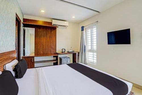 a bedroom with a white bed and a tv at Collection O SSR Royal Suites in Hyderabad