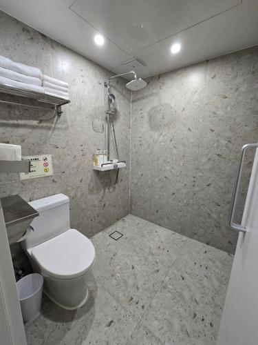 a bathroom with a white toilet in a room at Hotel The Grang Seogwipo in Seogwipo