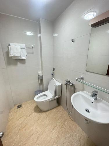 a bathroom with a toilet and a sink at Agarwood in Hanoi