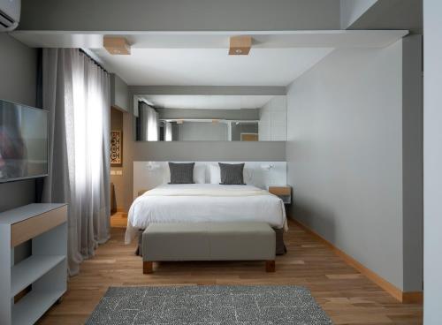 a bedroom with a white bed and a tv at Hotel Arenales in Buenos Aires