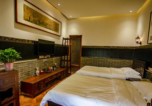 a bedroom with two twin beds in a room at Pingyao Grand Theater Guild Hall East Garden in Pingyao