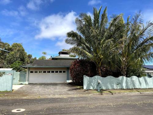 una casa con una palma e un garage di Lucy Fan Ohana a Haiku