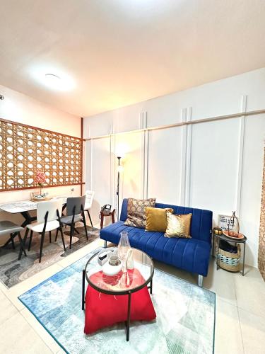 a living room with a blue couch and a table at 1-BR Suite with 2 Beds & Mountain Views in Aeon Towers beside Abreeza Mall 100MBPS WIFI in Davao City