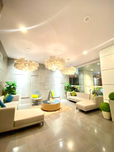 a living room with couches and chairs and chandeliers at 1-BR Suite with 2 Beds & Mountain Views in Aeon Towers beside Abreeza Mall 100MBPS WIFI in Davao City