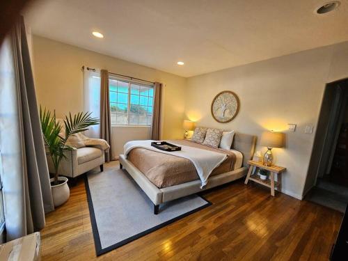ein Schlafzimmer mit einem Bett, einem Sofa und einer Uhr in der Unterkunft Stylish Ranch with Gorgeous Swimming Pool & Piano in Los Angeles