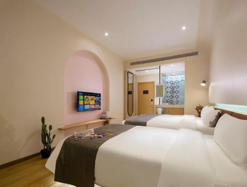 a hotel room with two beds and a tv at 小鹿辰客觅度设计民宿 in Luoyushangcun