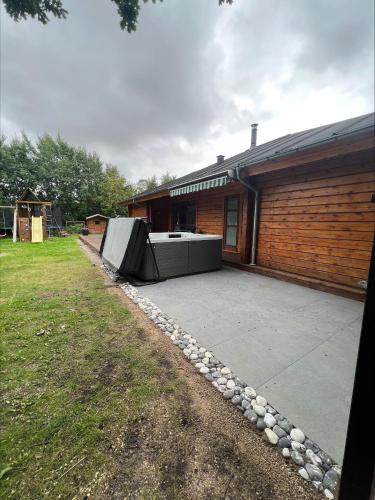 a backyard with a large patio and a building at Beautiful And Family-Friendly Holiday Home For 9 People With A Spa Bath Near Grenaa Beach in Grenå