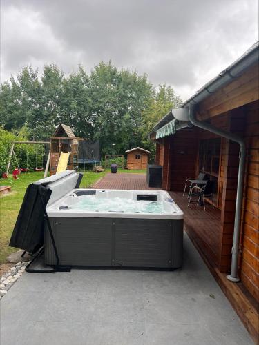 a hot tub on a patio next to a building at Beautiful And Family-Friendly Holiday Home For 9 People With A Spa Bath Near Grenaa Beach in Grenå