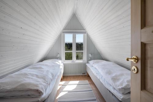 two beds in a room with a window at Charming And Well-Maintained Holiday Home With Lovely Sea View in Ebeltoft