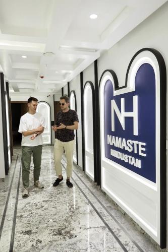 two men standing in a hallway next to a namineuseumuseum sign at Hotel Namaste Hindustan Just a Minute Away From New Delhi Railway Station and Connaught place in New Delhi