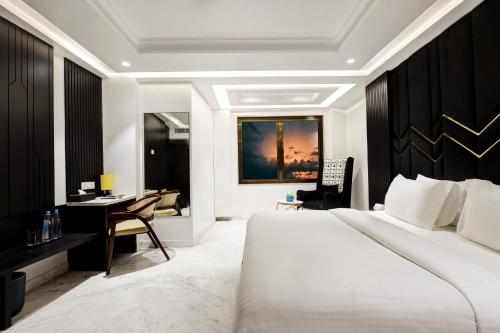 a bedroom with a white bed and a desk and a desk at Hotel Namaste Hindustan Just a Minute Away From New Delhi Railway Station and Connaught place in New Delhi