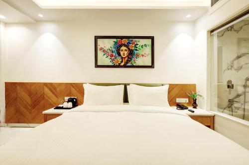 a bedroom with a white bed and a picture on the wall at Hotel Namaste Hindustan Just a Minute Away From New Delhi Railway Station and Connaught place in New Delhi