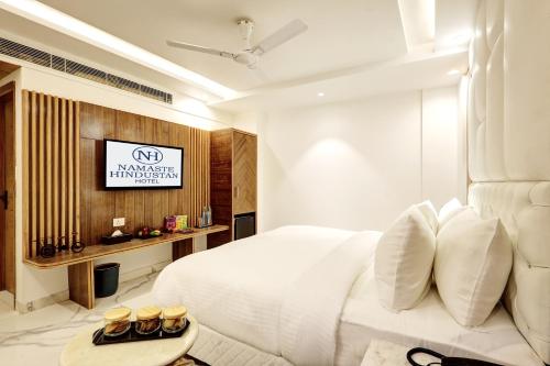 a bedroom with a white bed and a tv at Hotel Namaste Hindustan Just a Minute Away From New Delhi Railway Station and Connaught place in New Delhi