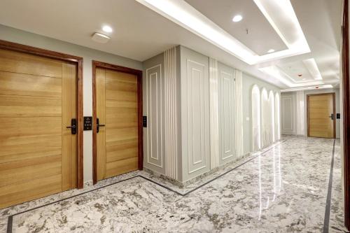 a hallway with wooden doors and a marble floor at Hotel Namaste Hindustan Just a Minute Away From New Delhi Railway Station and Connaught place in New Delhi