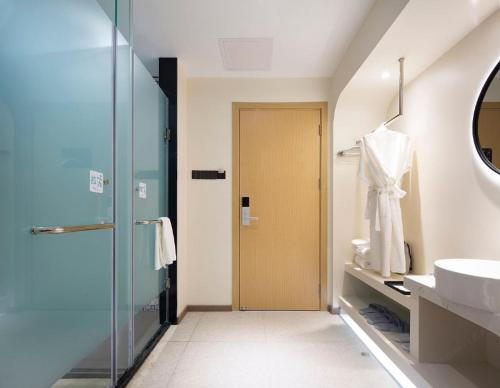 a bathroom with a glass shower and a sink at 小鹿辰客觅度设计民宿 in Luoyushangcun
