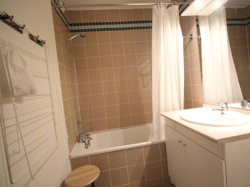 um banheiro com pia, banheira e chuveiro em Charmant T2 avec balcon, parking et lave-linge près du parc - FR-1-313-235 em Luchon