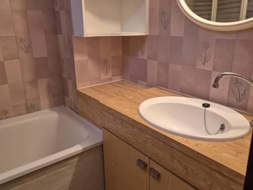 une salle de bain avec un lavabo et une baignoire dans l'établissement Appartement 4-6 pers, terrasse, parking, près du centre - FR-1-234-330, à Cauterets