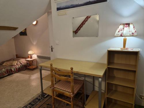 Cette chambre comprend un bureau avec une lampe et un lit. dans l'établissement Appartement 4-6 pers, terrasse, parking, près du centre - FR-1-234-330, à Cauterets