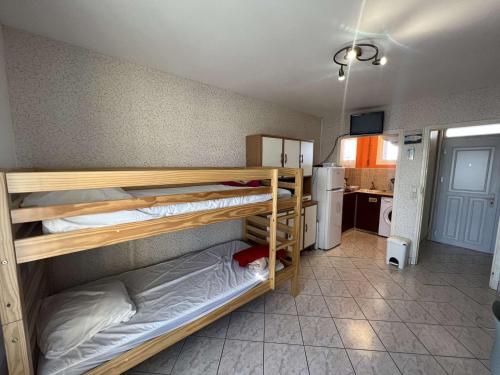 une chambre avec deux lits superposés et une cuisine dans l'établissement Studio abordable pour 4 personnes avec balcon près de la plage - FR-1-701-85, à Valras-Plage