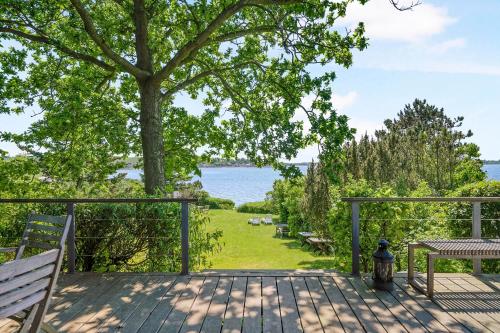 a deck with benches and a tree and the water at Awesome Home In Knebel With 2 Bedrooms And Wifi in Knebel