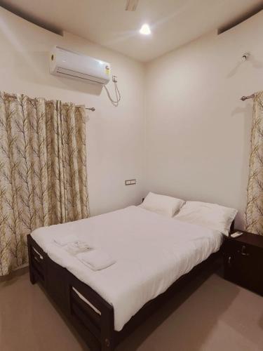 a bedroom with a bed and a air conditioner at Palm Paradise Home Stay in Varkala