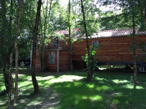une cabane en rondins entourée d'arbres dans l'établissement COLIBRI LOC - insolite - 3 étoiles - PARC - ETANG - FAMILLES - SOIREE OK, à Brigné