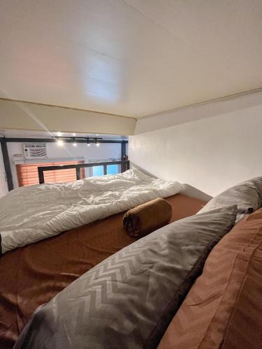two beds in a room with a window at Lee's Transient Unit 1 in Digos