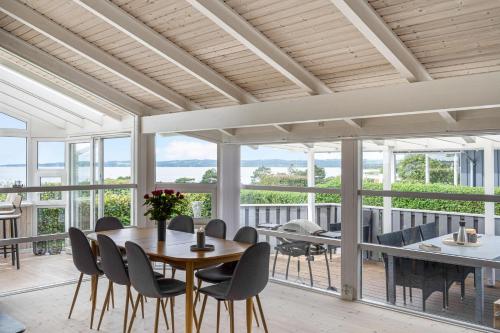 a dining room with a table and chairs at Beautiful Sea-View Holiday Home Near Ebeltoft Perfect For A Relaxing Stay By The Danish Coast in Ebeltoft