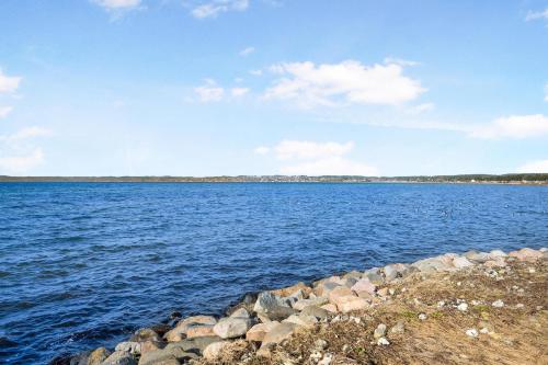 a large body of water with rocks on the shore at Nice Home In Ebeltoft With 0 Bedrooms And Wifi in Ebeltoft