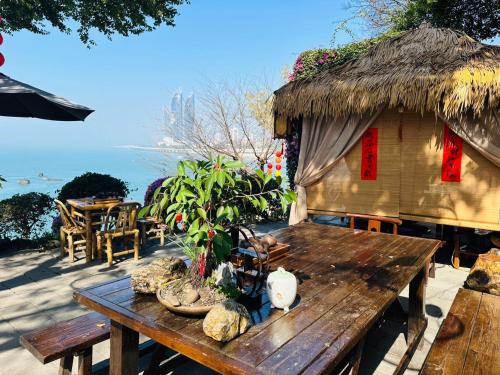 a wooden table and a hut with a table and chairs at City Hotel Xiamen-Free Welcome Fruits in Xiamen
