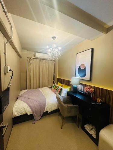 大阪市にあるe-hostel 心斎橋 404のベッドルーム1室(ベッド1台、デスク、シャンデリア付)