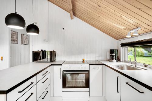 a kitchen with white cabinets and a sink at Cottage Near St Sjørup For 6 People in Ørsted