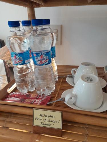 three bottles of water on a table with a sign at Tâm Homestay in Hue