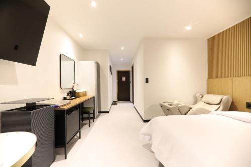 a bedroom with a bed and a desk and a mirror at Jeonju It's Hotel in Jeonju