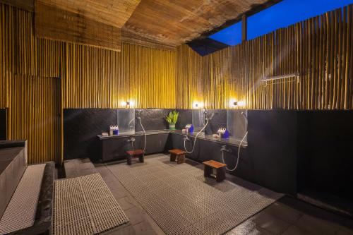 a bathroom with two sinks and benches in a room at Azumaya Hotel Kim Ma 2 in Hanoi