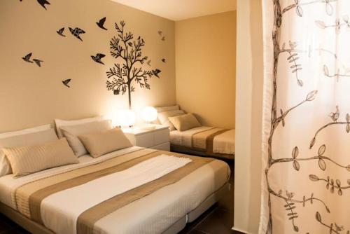 twee bedden in een slaapkamer met vogels aan de muur bij Casa Vacanze Lidia in Balestrate
