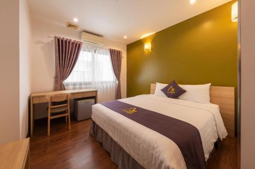 a bedroom with a bed and a desk and a window at Azumaya Hotel Kim Ma 2 in Hanoi