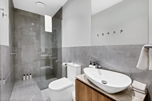 a bathroom with a toilet and a sink and a shower at Bokarina Beach Apartments, an Ascend Collection Hotel in Bokarina