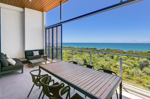 a balcony with a table and chairs and the ocean at Bokarina Beach Apartments, an Ascend Collection Hotel in Bokarina