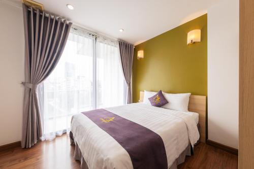 a bedroom with a bed and a large window at Azumaya Hotel Kim Ma 2 in Hanoi
