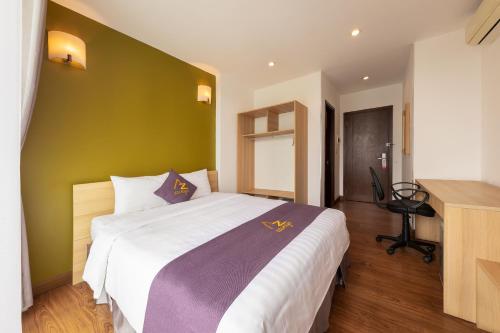 a bedroom with a large bed with a green wall at Azumaya Hotel Kim Ma 2 in Hanoi
