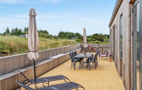 a patio with tables and chairs and umbrellas at 3 Bedroom Lovely Home In Fjerritslev in Fjerritslev