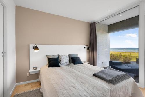a bedroom with a large bed with a large window at Well-Appointed Holiday Apartment With Panoramic Views Of Ebeltoft Vig in Ebeltoft